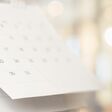 Close up white paper desk calendar with blurred bokeh background appointment and business meeting concept