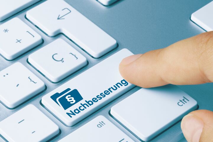 Nachbesserung Geschrieben am blauen Taste der metallischen Tastatur. Finger drückt die Taste.