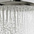 Wassertropfen fallen von einem metallenen Duschkopf