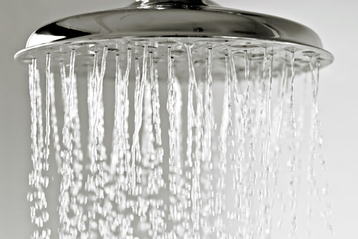 Wassertropfen fallen von einem metallenen Duschkopf