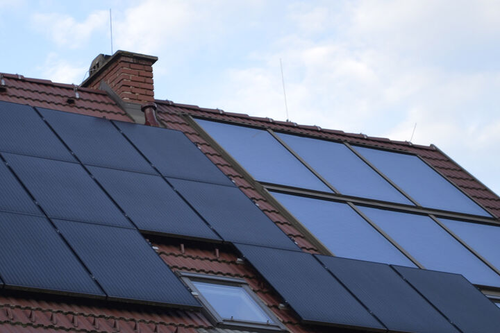 Solarthermie-Kollektor und Photovoltaik-Paneele auf einem Dach