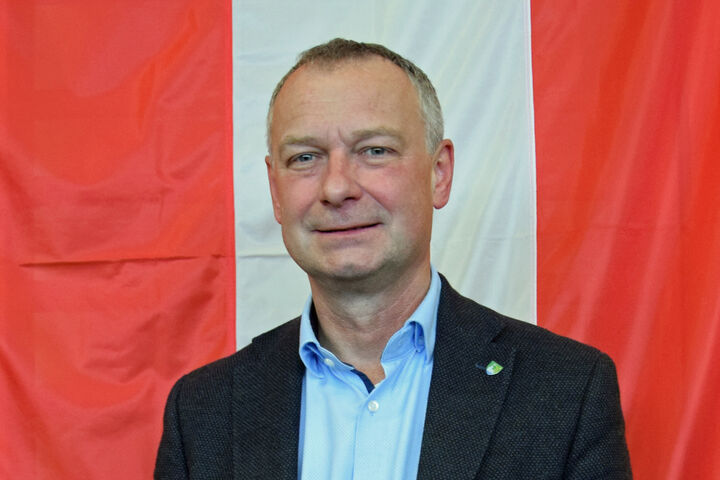 Manfred Denk vor der Österreich-Fahne