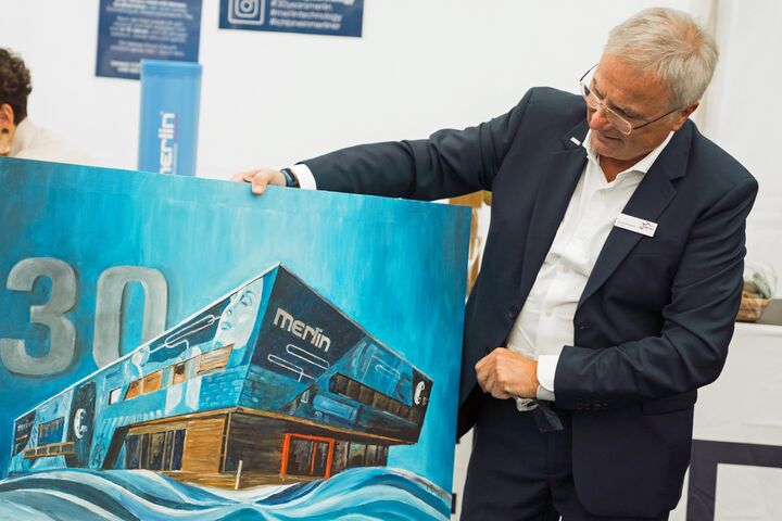 Gründer und CEO Johann Reisinger mit Kunstwerk zum 30-Jahr-Jubiläum von Merlin Technology