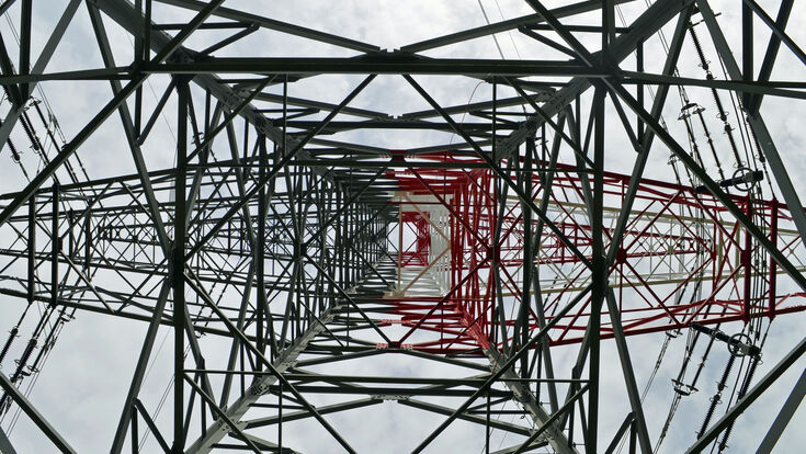 Hochspannungsmast von unten gesehen, der elektrische Energie an die Stromnutzer weiterleitet
