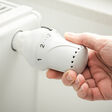 mit Wasser gefüllter Heizkörper und Thermostat, das gerade eingestellt wird