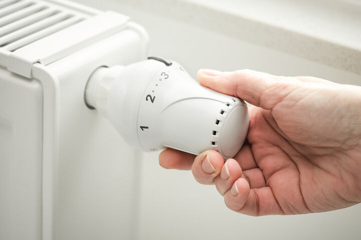 mit Wasser gefüllter Heizkörper und Thermostat, das gerade eingestellt wird