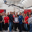 fischer BauBot Team mit Guiness World Records-Urkunde und Bauroboter im Hintergrund