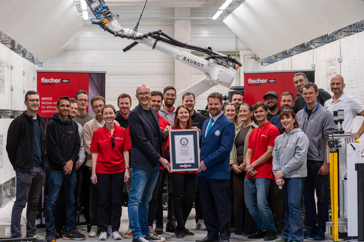 fischer BauBot Team mit Guiness World Records-Urkunde und Bauroboter im Hintergrund