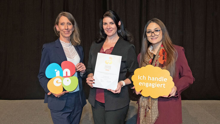 drei Damen weisen auf den INEO-Award für vorbildliche Lehrlingsausbildung hin, die der Sanitär- und Heizungsgroßhändler Holter von 2025 bis 2028 führen darf