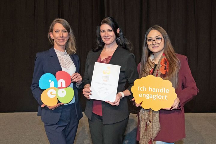 drei Damen weisen auf den INEO-Award für vorbildliche Lehrlingsausbildung hin, die der Sanitär- und Heizungsgroßhändler Holter von 2025 bis 2028 führen darf