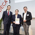 Doris Hofbauer (Takeda) und Johannes Riedl (AIT) nehmen den DECA Preis von Josef  Wolfbeißer entgegen