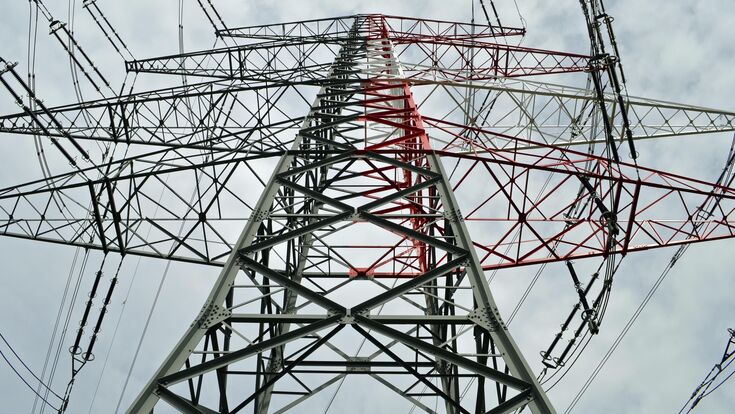 Blick von unten auf einen Strommast mit 380 kV Übertragungsspannung