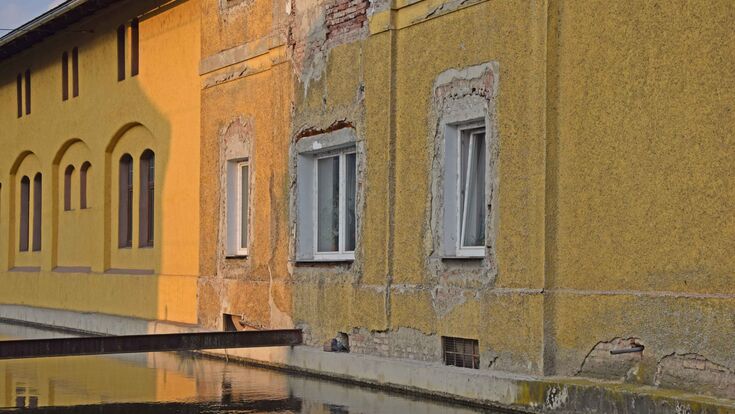 altes, sanierungsbedürftiges Gebäude neben einem Bach in Graz