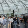 Personen begutachten ein Flugzeug, einen Hubschrauber und ein Formel 1-Auto im Red Bull Hangar-7
