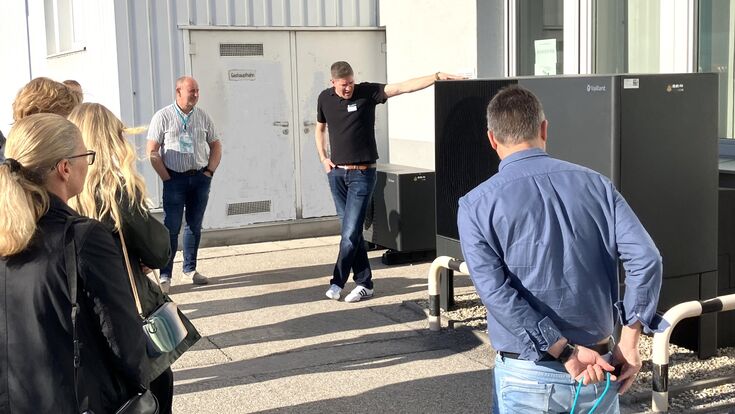 Fachleute stehen vor der Außeneinheit der Wärmepumpe aroTHERM perform bei Vaillant in Traun, Oberösterreich