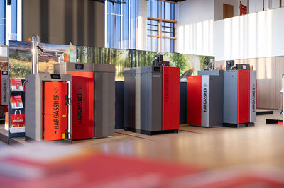 Im Ausstellungsraum der Hargassner Energy World, dem Firmenstammsitz der Hargassner Heiztechnik in Weng im Innkreis, Oberösterreich. Man sieht eine Reihe automatischer Biomasse-Heizkessel für Pellets, Hackschnitzel und Stückholz.