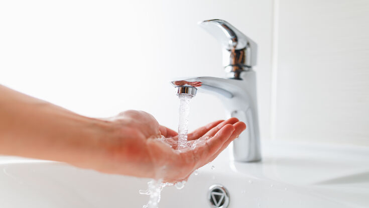 © iStockphoto.com/nikkytok faucet hand water bathroom close-up chrome metal sink indoors abstract new modern appliance apartment bright equipment clean furniture hygiene engineering shiny steel wet working white color washing touching stream - flowing water silver colored palm of hand single object light - natural phenomenon heat - temperature domestic life flowing cold temperature backgrounds physical pressure water pipe washbowl use tap put mixer